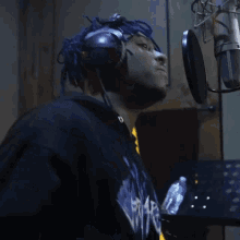 a man with blue hair is wearing headphones and a sweatshirt that says ' eminem ' on it