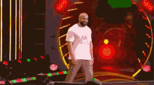 a man in a white shirt that says ' i love you ' on it stands in front of a circle of lights