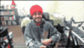 a blurry picture of a man wearing a red hat and a grey sweatshirt