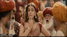 a woman in a red and gold dress is surrounded by men in turbans and the words pranay_varma on the bottom