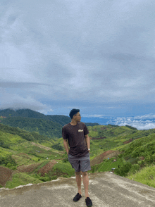 a man standing on top of a hill wearing a t-shirt that says ' abercrombie & fitch ' on it