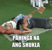 two women laying on a blanket with the words pahinga na ang shukla