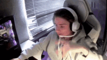 a man wearing headphones and a microphone is sitting in front of a computer .