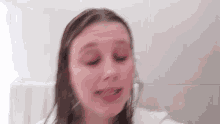 a blurry picture of a woman 's face with her hair hanging over her head