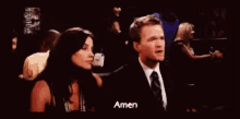 a man and a woman are clapping their hands in a crowd while the man says amen .