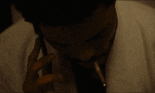 a man smoking a cigarette while talking on a phone