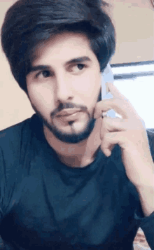 a man with a beard is talking on a phone