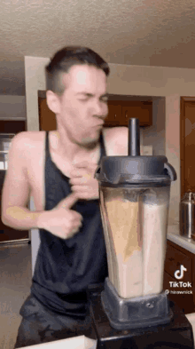 a man is making a smoothie in a blender with tiktok written on the bottom of the screen