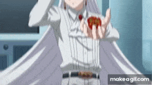 a girl in a white dress is holding a red object in her hands .