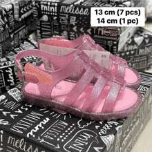 a pair of pink melissa sandals are sitting on a box