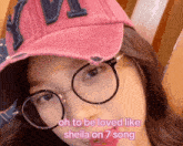 a woman wearing glasses and a pink hat with the words oh to be loved like sheila on 7 song