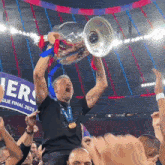 a man holds up a trophy in front of a banner that says ' league final 2025 '