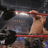 a man in a wrestling ring with a w logo on the side