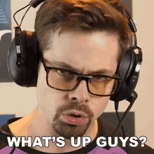 a man wearing headphones and glasses is asking what 's up guys