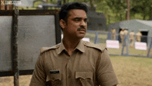 a man in a police uniform stands in front of a sign that says toms 2005