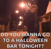a man in a mask is walking down a street at night with the words " do you wanna go to a halloween bar tonight "