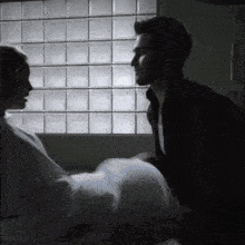 a man kissing a woman in a hospital bed in front of a window