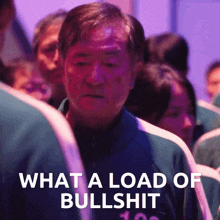 a man standing in a crowd with the words " what a load of bullshit " behind him