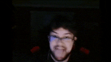 a blurry picture of a man wearing glasses and a beard