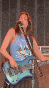 a woman singing into a microphone and playing a guitar