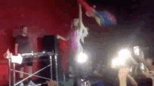 a woman is dancing on a stage while a man stands behind her