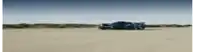 two racing cars are driving on a dirt road .