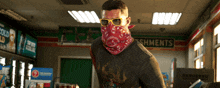 a man wearing sunglasses and a bandana in front of a sign for shments