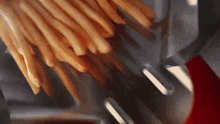 french fries are being cooked in a fryer with a red handle