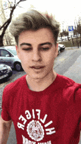 a young man wearing a red t-shirt with the word tiger on the front