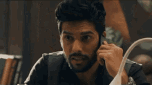a man with a beard is talking on a phone