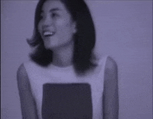 a woman is smiling in a black and white photo with a purple background
