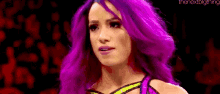 a woman with purple hair is standing in front of a red background and looking at the camera .
