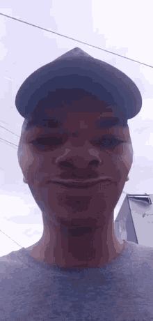 a young man wearing a hat is making a funny face