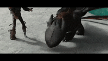 toothless and hiccup from how to train your dragon are standing in the snow .