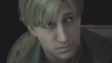 a close up of a man 's face with blonde hair looking at the camera .