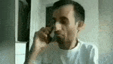 a man is talking on a cell phone while eating a chocolate bar .