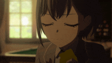 a girl with her eyes closed is holding a yellow object