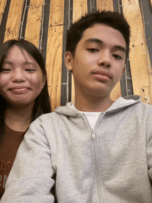 a boy and a girl are posing for a picture and the girl is wearing a shirt that says ' sunflower ' on it