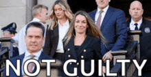 a group of people standing in front of a building with the words not guilty on the bottom