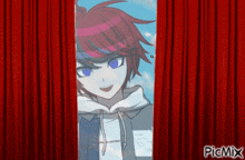 a picture of a boy with red hair and blue eyes behind a red curtain .