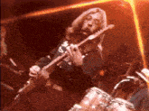 a man with long hair is playing a guitar with a shirt that says ' a ' on it