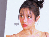 a close up of a woman 's face with a bun on her hair
