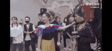 a woman in a snow white costume is standing next to a man in a horned hat .