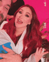 a woman with red hair and a man with a beard are posing for a photo