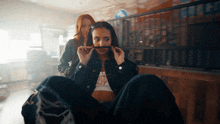 a woman in a denim jacket has a sticker on her shirt that says ' i 'm a bitch '