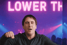 a man in front of a sign that says lower th