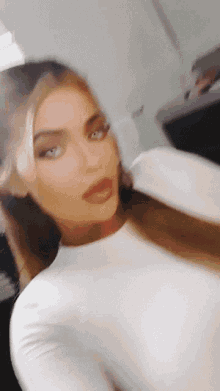 a close up of a woman 's face with a white shirt on