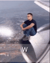a man is sitting on the wing of an airplane ..