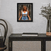 a picture of a woman in a crop top and shorts is hanging on a wall above a table
