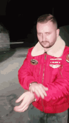 a man in a red jacket has a patch on his chest that says ' aviator '